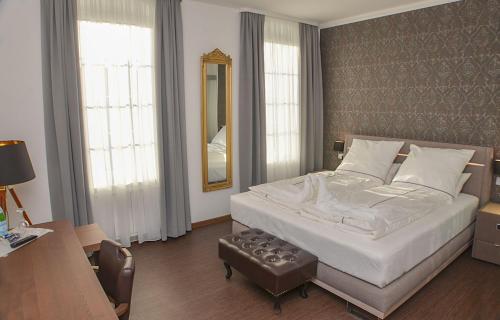 BeverstedtVittoria Hotel-Restaurant的一间卧室配有一张床、一张书桌和一面镜子