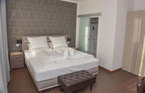 BeverstedtVittoria Hotel-Restaurant的一间卧室配有一张带白色床单的大床
