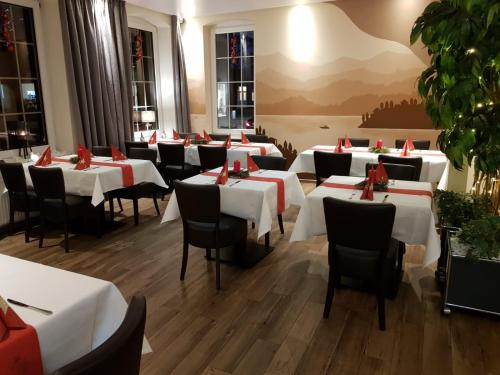 BeverstedtVittoria Hotel-Restaurant的用餐室配有白色桌子和黑色椅子