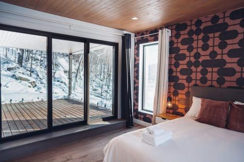 圣阿黛拉Lakeview Mid Century Luxury Cottage的一间卧室设有一张床和一个大窗户