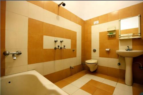 新德里HOTEL AIRPORT INN near Delhi Airport的带浴缸、卫生间和盥洗盆的浴室