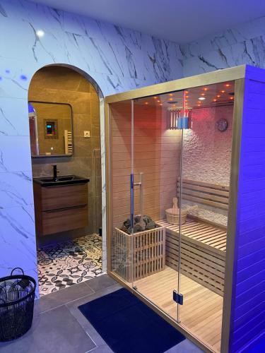 CrouyLa nuit de rêve Spa privatif Jaccuzi Sauna suite 1的设有带梳妆台和盥洗盆的淋浴的浴室