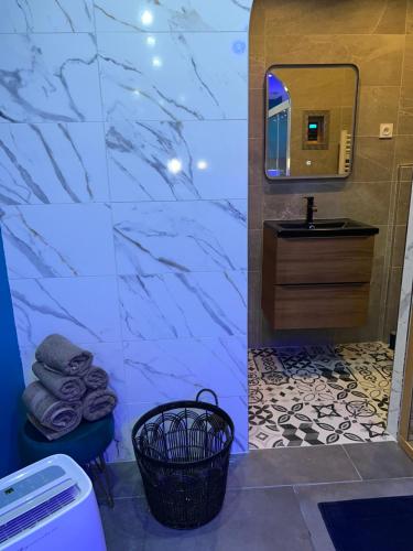 CrouyLa nuit de rêve Spa privatif Jaccuzi Sauna suite 1的一间带水槽和镜子的浴室