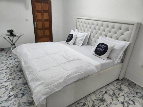 杜阿拉Chambre Meublée à Douala, Bonapriso - Armée del'air的一张带两个枕头的大白色床