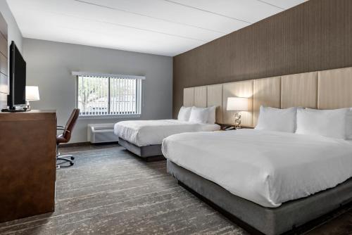 Amwell Suites Somerset/Bridgewater的酒店客房设有两张床和一台平面电视。