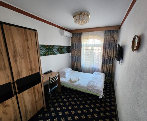 塔什干Heyvah - Guest House in Tashkent的小房间设有一张床和一张书桌
