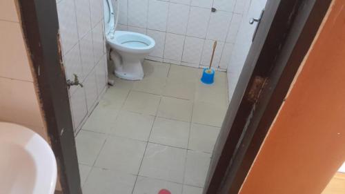 金贾Meral inn Jinja的一间带卫生间和马桶刷的浴室