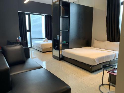吉隆坡Klcc Suites at Axon By Skypool的一间卧室配有两张床、一把椅子和一张沙发