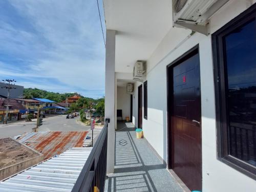 SibengkokGuesthouse Cempaka的带有门和街道的建筑阳台