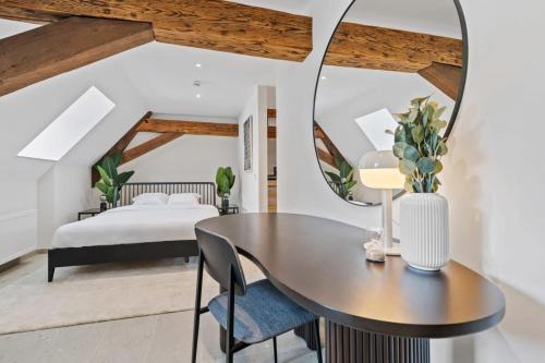 卢森堡Escape to Clausen Stylish Apartment ID212的一间卧室配有桌子、床和镜子