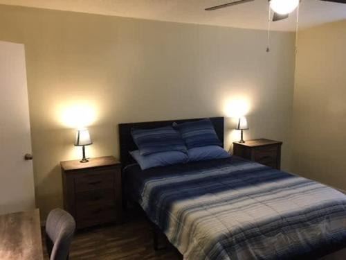 劳顿Simple 1-bedroom unit upstairs close to Fort Sill!的一间卧室配有一张带2个床头柜和2盏灯的床。