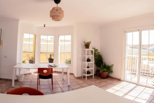 厄尔梅达诺Integral Coliving Surf Yoga House的白色的客房配有桌椅和窗户。