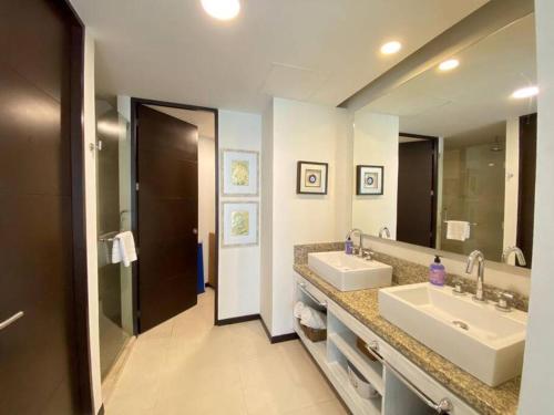 坎昆Departamento frente al mar的一间带两个盥洗盆和大镜子的浴室