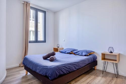 拉戈尔Maison T4 Climatisée avec Jacuzzi à Lagord的一间卧室配有一张带蓝色床单的床和一扇窗户。