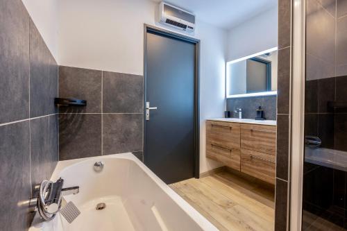 拉戈尔Maison T4 Climatisée avec Jacuzzi à Lagord的带浴缸和盥洗盆的浴室