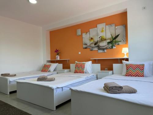 贝尔格莱德Flamingo Resort的橙色墙壁的房间里设有三张床