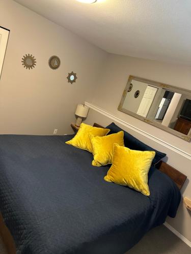 纳奈莫Pleasant Valley Vacation Suite的一间卧室配有蓝色的床和黄色枕头