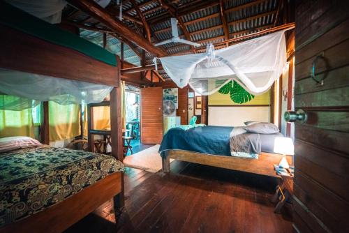里约杜尔塞Hotel Casa Perico的一间铺有木地板的客房内配有两张床的卧室