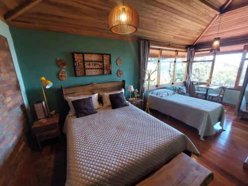 圣本图-杜萨普卡伊Hospedaria Aikó的一间设有两张床的卧室,位于带绿色墙壁的房间