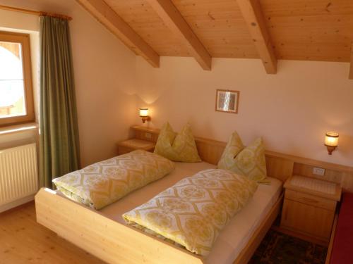 圣坎迪朵Oberpapping的一张位于房间的床,上面有两个枕头