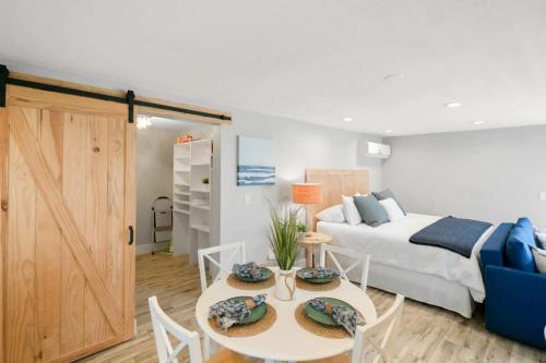 圣奥古斯丁Coral Cottage, Stylish Studio Suite on Canal, Walkable to Beach, Private Parking的一间卧室配有一张床和一张桌子及椅子