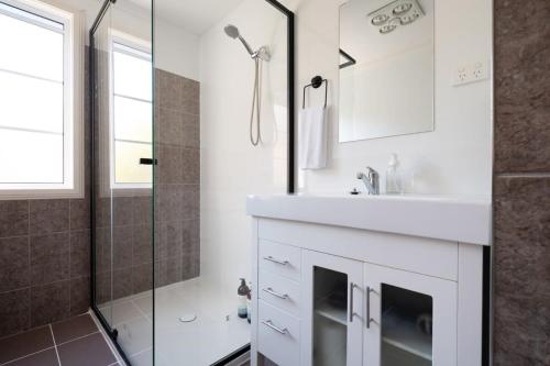 Kings ParkStation Cottage的白色的浴室设有水槽和淋浴。
