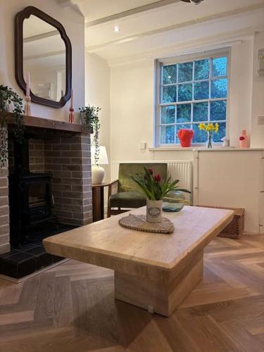阿什伯恩Rosie Cottage的客厅配有桌子和壁炉