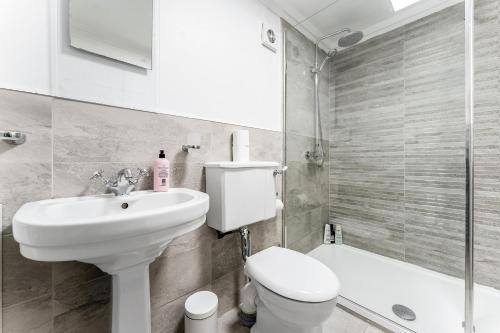 格拉斯哥Luxurious Park District Duplex Apartment的白色的浴室设有卫生间和水槽。