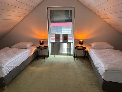 蒂宾根Hotel Am Kupferhammer的阁楼间设有两张床,设有窗户
