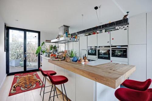 布洛涅-比扬古Appartement avec terrasse的厨房配有带红色吧台凳的吧台