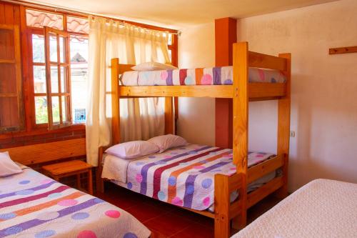 奥克萨潘帕HOSPEDAJE SCHASCA的一间卧室设有两张双层床和一扇窗户。