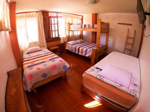 奥克萨潘帕HOSPEDAJE SCHASCA的一间卧室配有两张床和一张双层床。