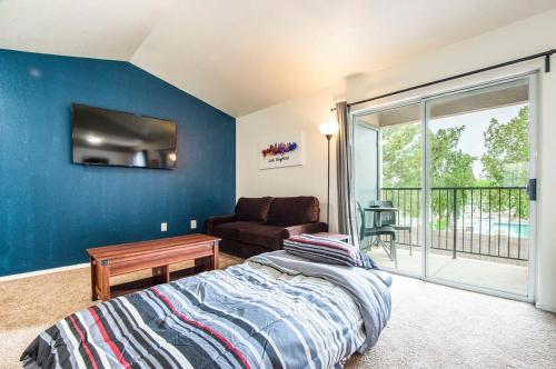 Coolidge213- 2BR Apartment in Coolidge, AZ w heated pool, gym的一间卧室配有一张床、一张沙发和一个窗口