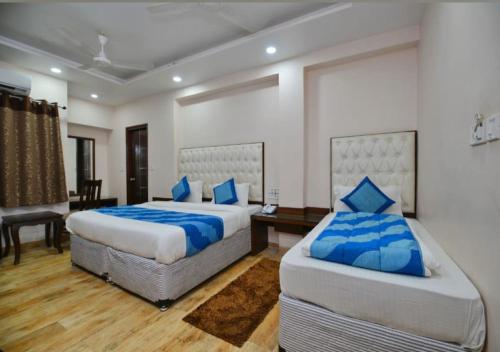 新德里Hotel Kabeer By A1Rooms的一间卧室配有两张带蓝色枕头的床