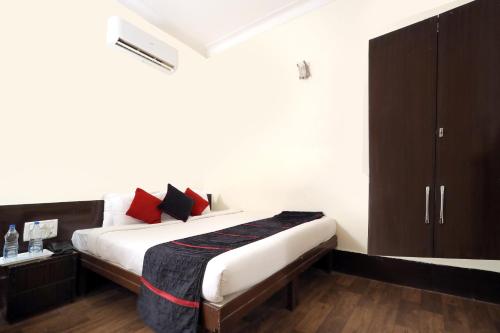 瓜廖尔TRP VIVEK CONTINENTAL的一间卧室配有红色和黑色枕头的床