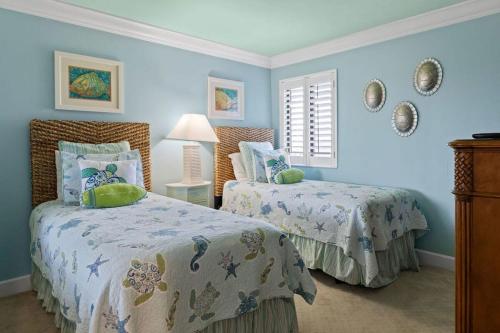 迈尔斯堡Gorgeous Renovated Residence in Upscale Sanibel Harbour Tower的卧室设有两张床铺和蓝色的墙壁