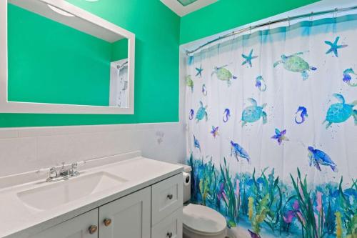 迈尔斯堡Cute Coastal Home with Pool的浴室设有淋浴帘,上面有鱼