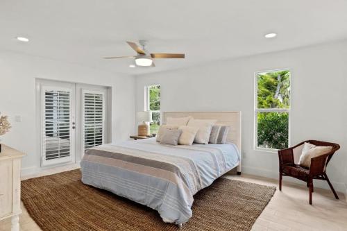 萨尼贝尔Sanibel Serenity- NEW Gorgeous Near Beach Villa with Pool的一间卧室配有一张床、一把椅子和窗户。