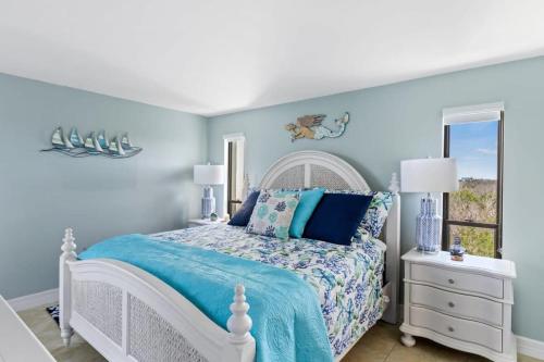 迈尔斯堡Stunning Waterfront Residence with Panoramic Water Views的一间蓝色的卧室,配有白色的床和窗户