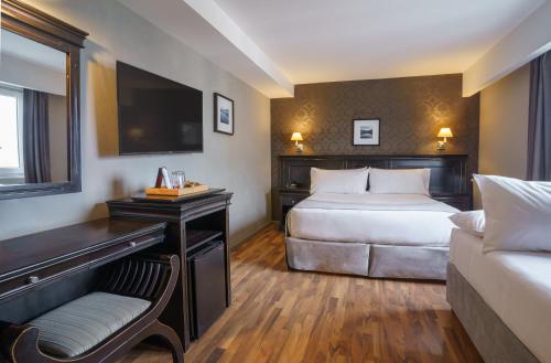 乌斯怀亚乌斯怀亚论诺克斯酒店的酒店客房配有一张床、一张书桌和一台电视。