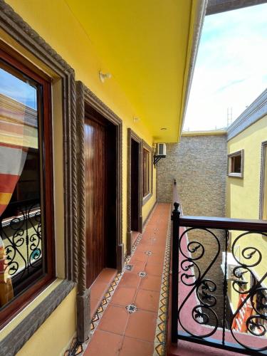 阿瓜斯卡连特斯Hotel La Casa de María Joyita的阳台设有锻铁栏杆和窗户。