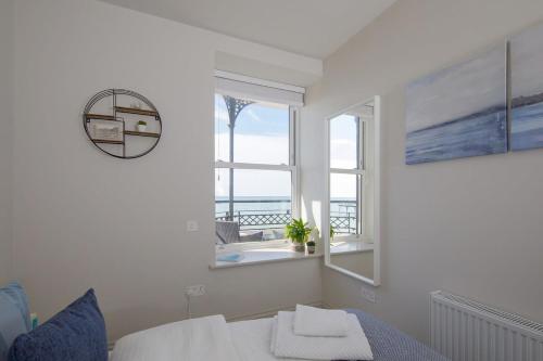 博格诺里吉斯Panoramic sea views in beachfront apt w balcony的一间卧室设有一张床和一个享有海景的窗户。