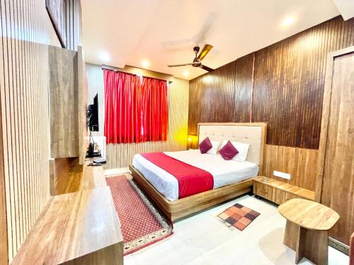 瓦拉纳西HOTEL SIDDHANT PALACE ! VARANASI fully-Air-Conditioned hotel at prime location, Lift-&-wifi-available, near-Kashi-Vishwanath-Temple, and-Ganga-ghat的一间卧室配有床和红色窗帘