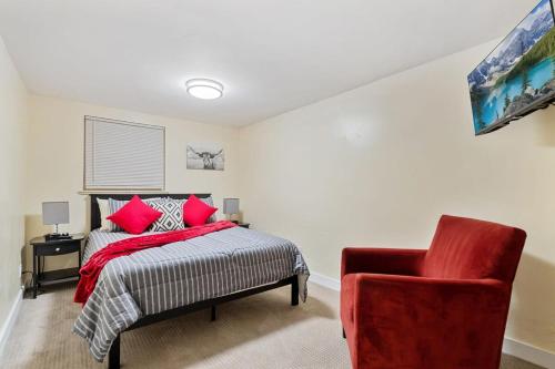 丹佛Cozy & Spacious Apartment Steps From Regis的一间卧室配有一张床和一张红色椅子