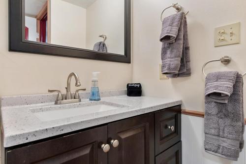 丹佛Cozy & Spacious Apartment Steps From Regis的浴室配有盥洗盆、镜子和毛巾