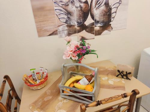 塞萨洛尼基Studio Luxury Maria Xoulia的一张桌子,上面放着一篮水果和花瓶