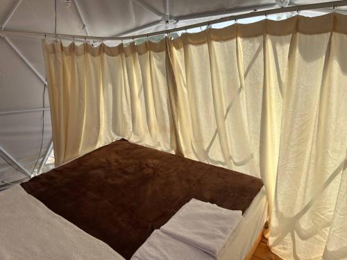 拉多维奇Glamping ROSE (Luštica Bay)的帐篷内的一张床位,配有白色窗帘