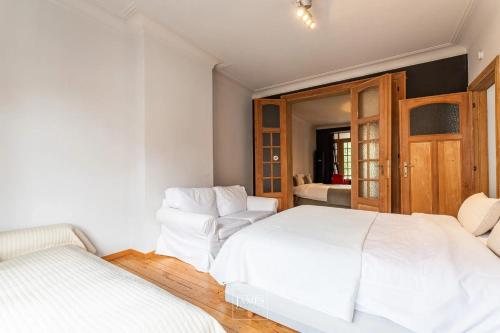 布鲁塞尔3 bedrooms apartement with enclosed garden and wifi at Bruxelles的一间白色卧室,内配两张白色的床