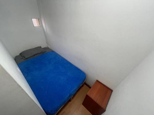 波哥大Hostel Bogotá Niza Tu sitio的小房间设有蓝色的床和木桌