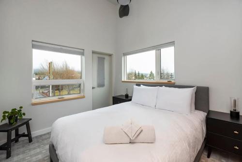怀特霍斯NN - The Flame - Downtown 1-bed 2-bath的卧室配有一张白色大床和两个窗户